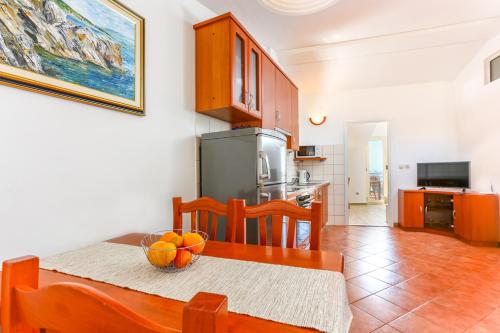 a kitchen with a table with a bowl of fruit on it at Pina Hvar Seaview Apartment in Hvar