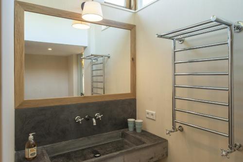 een badkamer met een wastafel en een spiegel bij Dromen in Drempt in Drempt