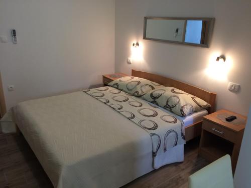 a bedroom with a bed and a mirror on the wall at Apartments Nevenka i Josko in Tučepi