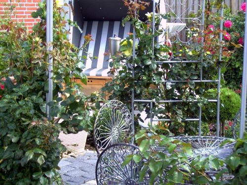 a garden with two chairs and some plants and flowers at Haus Kamp in Tinnum