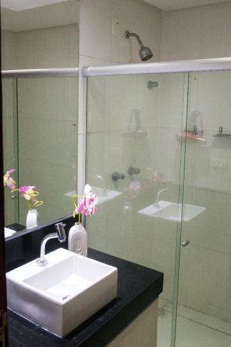 a bathroom with a sink and a glass shower at Pipas Ocean in Pipa