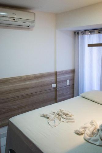 a bedroom with a bed with two towels on it at Pipas Ocean in Pipa