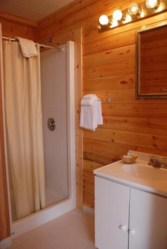 a bathroom with a shower and a sink at Triple J Hotel in Dawson City