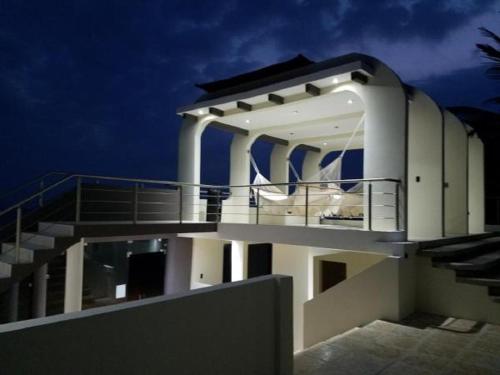 a large white building with stairs on top of it at Casa Margarita Hotel And Paradise in Las Lisas