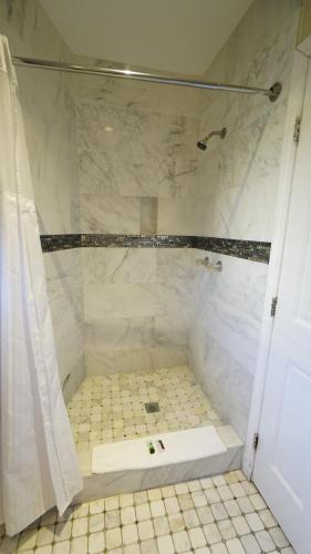 a bathroom with a shower with a tiled floor at Trylon Hotel - Hollywood in Los Angeles