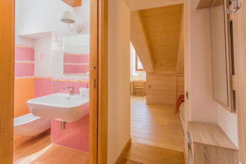 ein Badezimmer mit einem weißen Waschbecken und rosa Fliesen in der Unterkunft B&B White Moon in Gressoney-la-Trinité