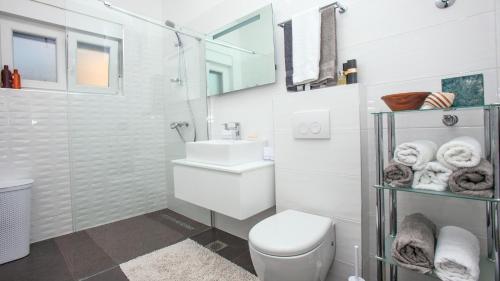 La salle de bains blanche est pourvue de toilettes et d'un lavabo. dans l'établissement apartman ami, à Split