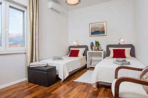 a bedroom with two beds and a window at apartman ami in Split