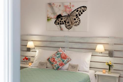 a bedroom with a bed with a butterfly on the wall at Letta's Apartments in Finikas