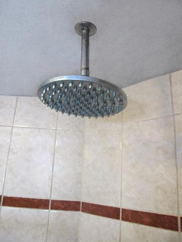 a metal light hanging from a ceiling in a shower at Solis Dies Hotel in Lima