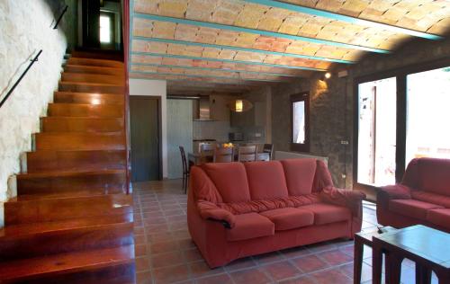a living room with a couch and a staircase at Mas Serrat de la Teia in Sant Joan de les Abadesses