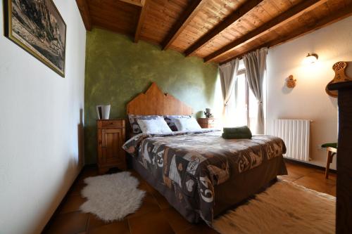 una camera con un letto in una stanza con una finestra di Maison I Love Mont Blanc a Courmayeur