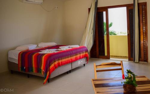 um quarto com uma cama com um cobertor colorido em Pousada Brisa Marine em Conde