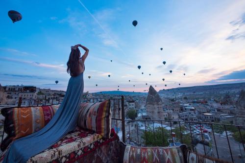 a woman flying a kite on top of a city at Vista Cave Hotel in Göreme