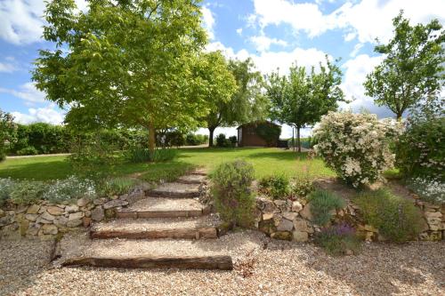 a garden with a stone path and trees at les gîtes de l'argenterie à 15km du zoo de Beauval classés 4 étoiles in Fontguenand