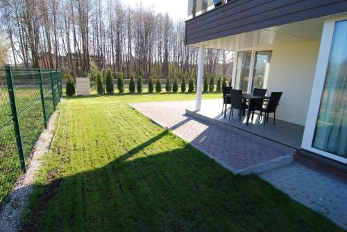 Atsipūskit في بالانغا: منزل به طاولة وكراسي على العشب