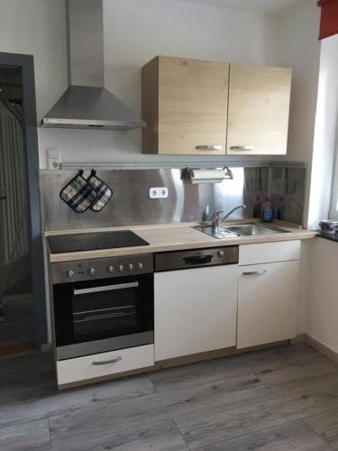 a kitchen with a stove and a sink at Ferienwohnung Gartenstrasse in Gersfeld