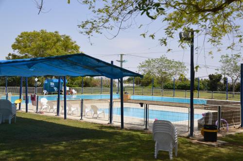 una piscina con sedie e tettoia blu di Shkutai Hottub Arava a Ẕofar