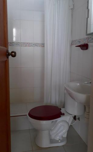 a bathroom with a toilet and a sink at Alojamiento Familiar Villa Palmeras in Tarapoto