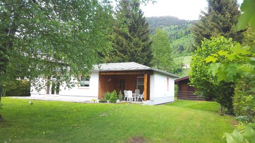 a small white house with a porch and a yard at Haus Gerti in Zell am See