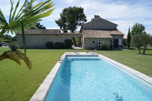 une piscine dans une cour avec une maison dans l'établissement Gîtes dans Mas en pierres, à Robion