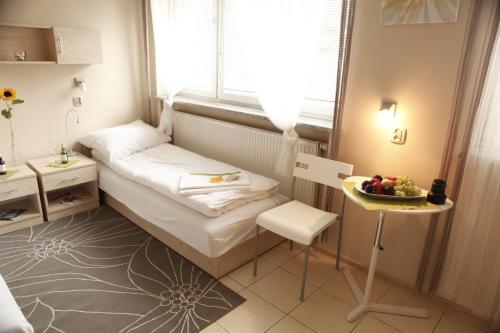 a small room with a bed and a table and a window at Standard Delegacyjny Bed & Breakfast in Dąbrowa Górnicza
