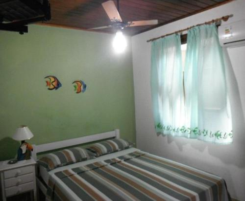 a bedroom with a bed and a window at Alebelhinha Residencial Camburi Pousada in Camburi