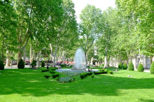 a fountain in a park with green grass and trees at Lovecroatia Zagreb - 'Pax nest' in Zagreb