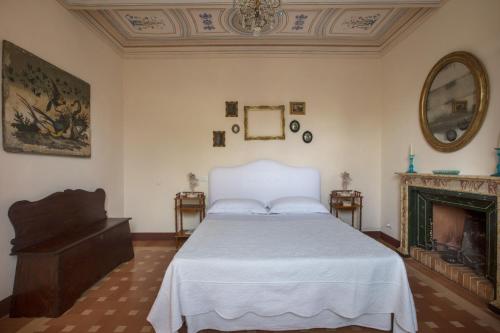 a bedroom with a white bed and a fireplace at Dimora Rosa Bianca in Macerata