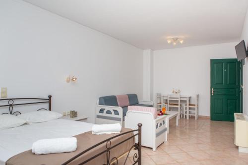 a bedroom with two beds and a chair and a table at Golden Bay in Agios Prokopios