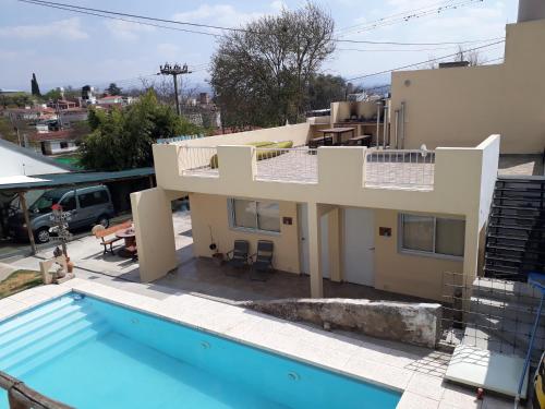 una casa con piscina frente a una casa en LA FOGLIA departamentos en Villa Carlos Paz