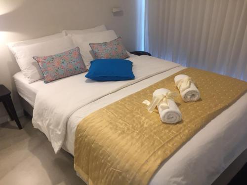 a bed with towels and shoes sitting on it at Different Atmosphere Suite in Caesarea