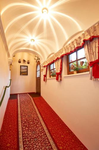 a hallway with a red carpet and windows at Hotel Garni Ransburgerhof in Flachau
