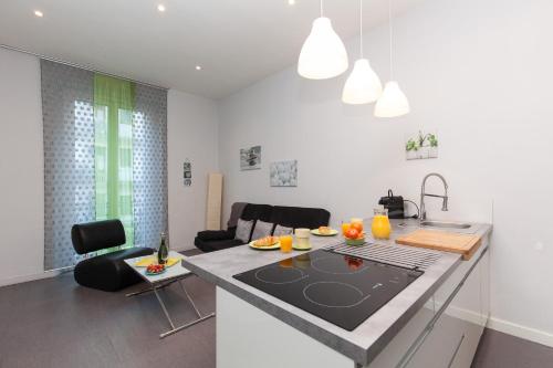 une cuisine et un salon avec un comptoir dans l'établissement ZEN 2 pièces 3 étoiles, plein centre cannes, à 5mn des plages et du palais, à Cannes