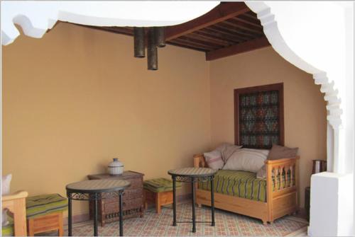 a room with a bed and two tables in a room at Hôtel Ras El Maa in Chefchaouene