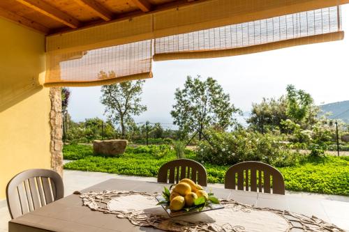 a table with chairs and a bowl of fruit on it at Borgo dell'Uccellaia - Smeraldo in Marciana Marina