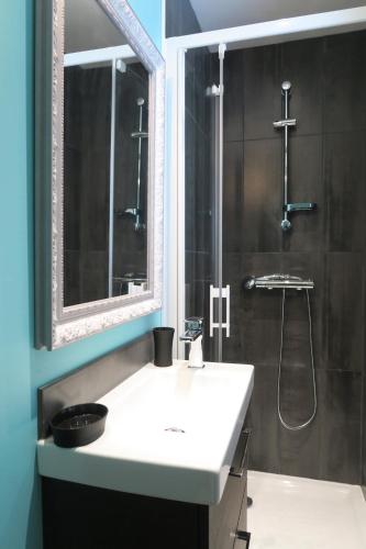 a bathroom with a white sink and a shower at SMILE APPARTS - Appartements - Au coeur de Lorient - Au calme - Tout Confort in Lorient