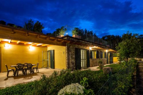 a patio with a table and chairs at night at Borgo dell'Uccellaia - Smeraldo in Marciana Marina
