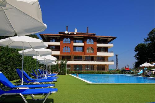 a hotel with chairs and umbrellas next to a swimming pool at Complex Hunter's Beach in Shkorpilovtsi