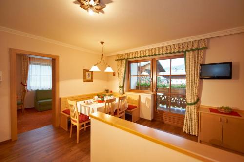 a kitchen and living room with a table and a dining room at Hotel Garni Ransburgerhof in Flachau