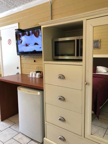 a cabinet with a microwave and a tv in a room at Lakeside Inn and Cafe in Saint Cloud