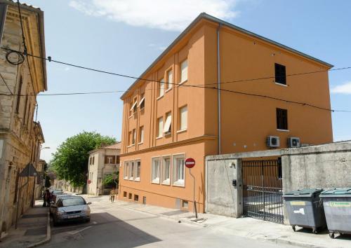a orange building with a car parked next to it at San Martino Rooms in Pula