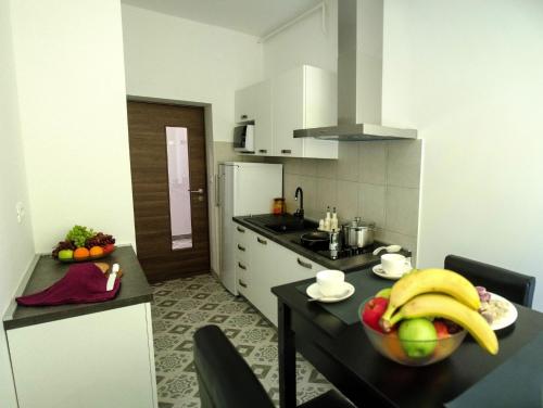 a kitchen with a table with a bowl of fruit on it at San Martino Rooms in Pula