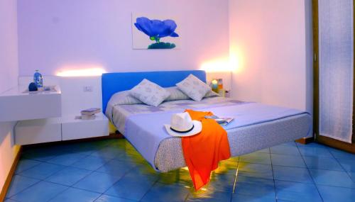 una camera da letto con un letto con un cappello sopra di Luna Rossa a Castel di Tusa