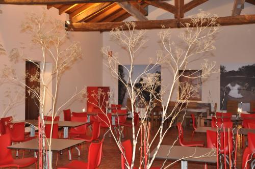 two trees in a room with red chairs and tables at Carrecalzada in Melgar de Fernamental