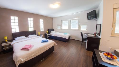 Habitación de hotel con 2 camas y TV en Guesthouse Stari Grad, en Mostar