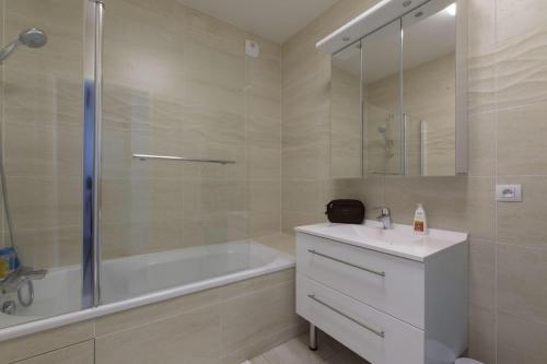 La salle de bains est pourvue d'une baignoire, d'un lavabo et d'une douche. dans l'établissement Porte de Versailles et Parc des Princes, à Issy-les-Moulineaux