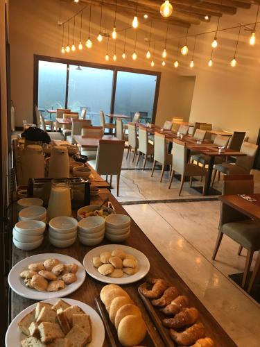 a long table with plates of bread and pastries at Posada del Blanco in Potrerillos