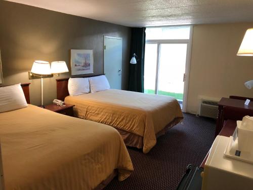 a hotel room with two beds and a window at Norwood Inn & Suites Worthington in Worthington