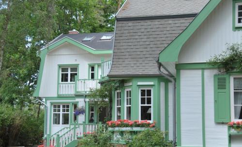 a house with green trim and flowers in the windows at Landhaus Victoria in Boltenhagen